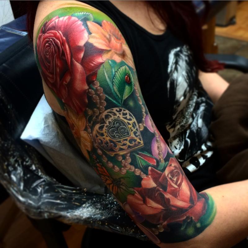 Realistic roses with locket and lady bug color tattoo