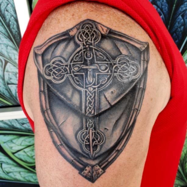 Celtic Cross Embedded within a Battle-torn Shield by Victor Alvarez:  TattooNOW
